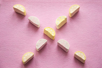 Colorful mini marshmallows on pink background, closeup. Fluffy marsh mallows texture and pattern.