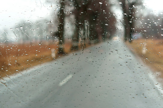 Raindrops on car glass. Wet asphalt. Rain on glass. Drive on highway in heavy rain.
