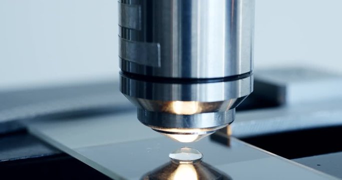 Close up shot of the scientist studies examining of test sample under the microscope in laboratory.