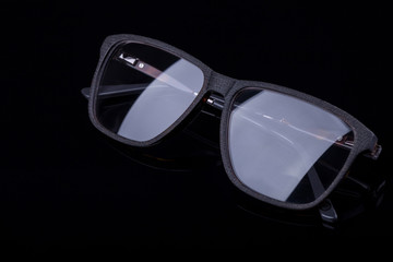 Elegant glasses on a black background with a mirror image