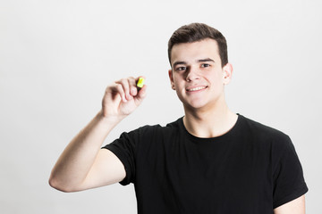 Young man drawing with marker on empty copy space isolated on white background