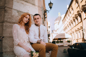 young and beautiful woman and man sitting outdoors