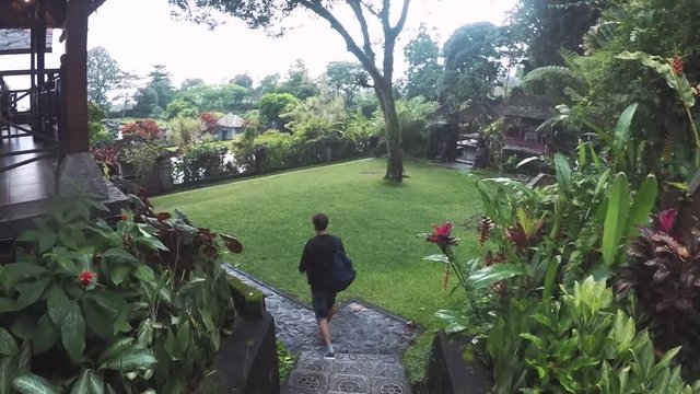 A young man descends an authentic staircase in a temple on a tropical island