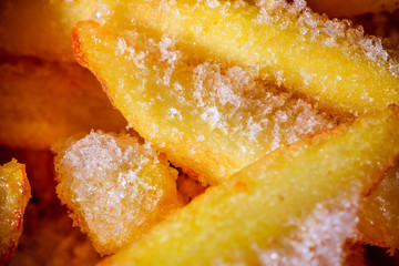Frozen french fries close-up, salt, ice, textured background