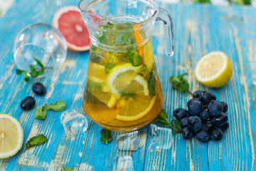 carafe with lemon drink, fruit and mint