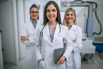 Smiling female doctor and nurses in hospital.