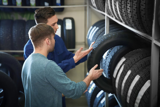 Service center consultant helping customer to choose tire in store
