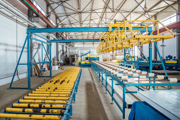 Naklejka premium Insulation sandwich panel production line. Machine tools, roller conveyor in workshop