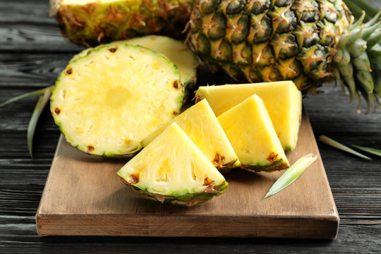 Fresh sliced pineapple on wooden board, closeup