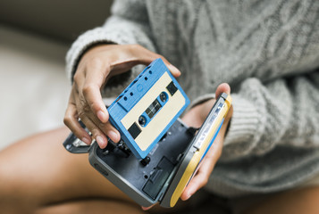 Woman putting a cassette in a cassette player