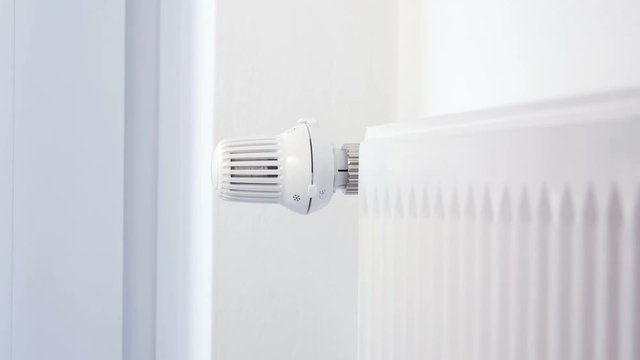 House heating - Hand adjusts the heating thermostat