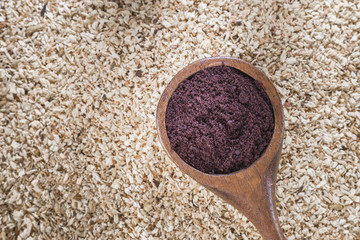 Acai powder in bowl on wooden background