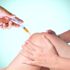 Doctor hand holding syringe of platelet rich plasma for injection to knee.