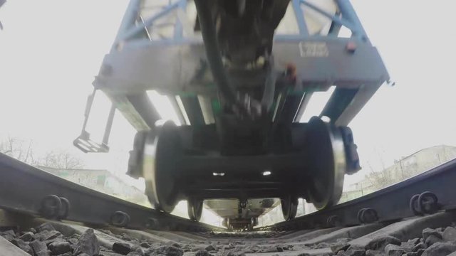 A view from below on the railway and freight train in motion. Close-up of the wheels. The camera on the sleepers under the train. Dangerous. Travel concept