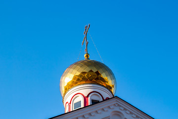 Gold-plated dome of the Russian Orthodox Church against the blue sky
