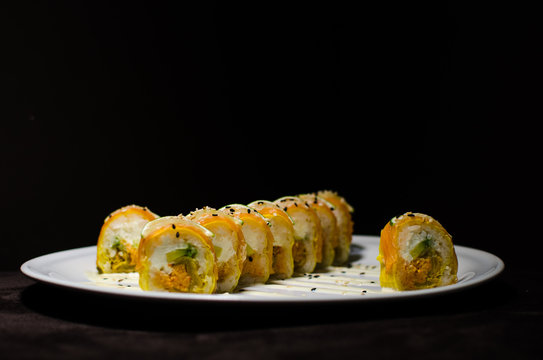 Sushi rolls in white plate and dark background