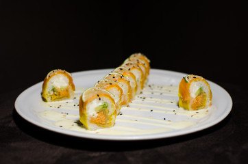 Sushi rolls in white plate and dark background