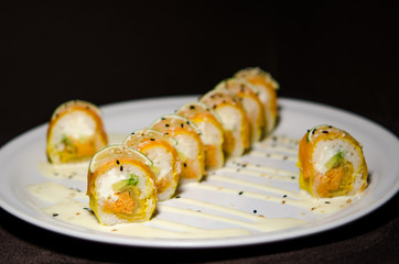 Sushi rolls in white plate and dark background