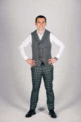 stylish man in checkered suit on a gray background