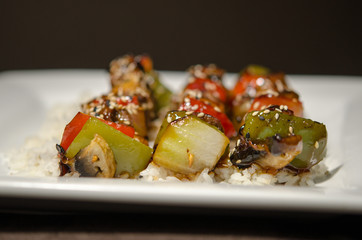 japanese brochette in black background and white plate