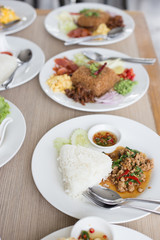 Many Thai food on white plates ready for eating