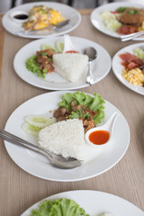Many Thai food on white plates ready for eating