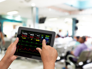 Doctor online checking patient monitor by use Tablet and wifi technology in intensive care unit...