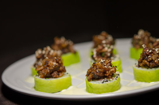 Sushi rolls in white plate and dark background