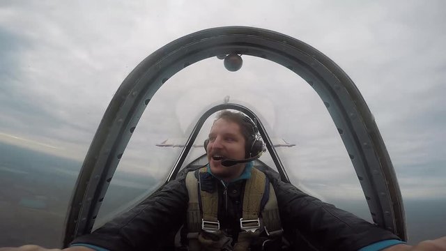 Smiling pilot sitting in the cockpit of a light aerobatic aircraft, emotions from the flight, aerobatics