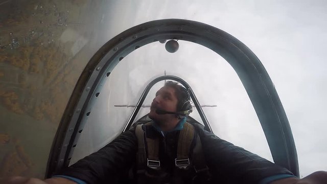 Smiling pilot sitting in the cockpit of a light aerobatic aircraft, emotions from the flight, aerobatics