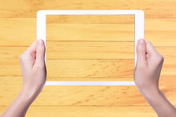 Obraz premium tablet in woman's hands on blurry wood background