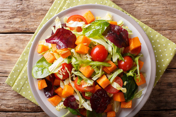 Delicious organic salad of sweet potato with fresh vegetables close-up on a plate. horizontal top view