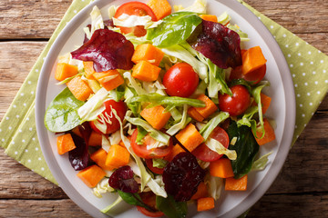 healthy food: vegetarian salad of sweet potato with fresh vegetables close-up on a table. horizontal top view