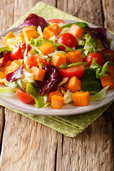 healthy food: vegetarian salad of sweet potato with fresh vegetables close-up on a plate on a table. vertical