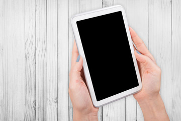 Woman hand using mock up digital tablet clipping patch on wood white light background