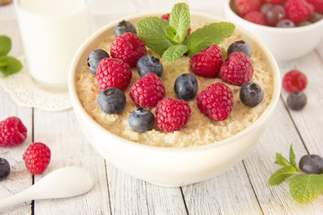 Oatmeal with raspberries.Healthy food for breakfast.Tasty oatmeal with berries in bowl on table