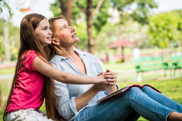 Mother and daughter relaxing in a park. Family and lifestyle concept