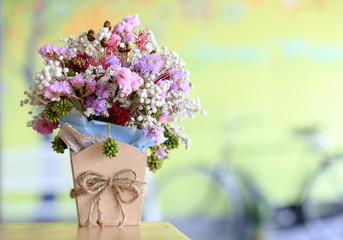 Flower bouquet in brown vase with blurred background of bicycle 