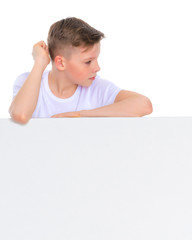 A boy of school age near a white advertising banner.