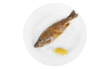 Fish trout whole with a head, baked fried over an open fire with a slice of lemon and ground pepper. Appetizing juicy natural on white isolated background View from above For the menu, restaurant, bar