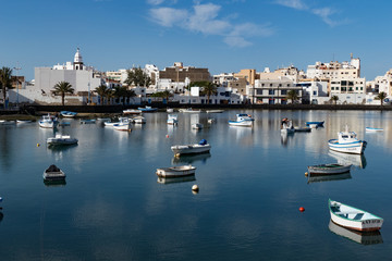 Fototapeta na wymiar Kleiner Hafen mit vielen kleinen Booten auf der Insel Lanzarote an enem Sonnentag