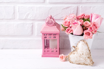 Pink roses flowers  in white pot, decorative heart and pink lantern