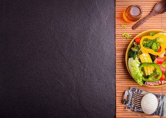 Salad healthy food on wood and black stone background. Weight loss. Copy space.