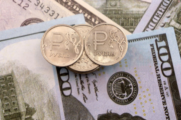 coin one ruble against the background US dollars background .