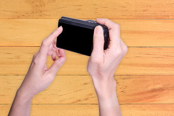 Mirrorless camera  in hand on wood background