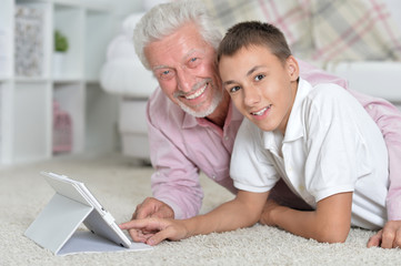 Grandfather and grandson lying on floor