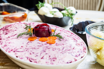 preparing russian traditional salad 'herring under fur coat'
