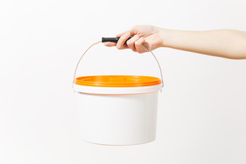Close up of female hand horizontal holds empty paint bucket with copy space isolated on white background. Instruments, accessories for renovation apartment room. Repair home concept. Advertising area.