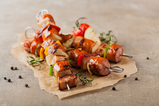 Grilled skewers with sausage, bacon and vegetables.