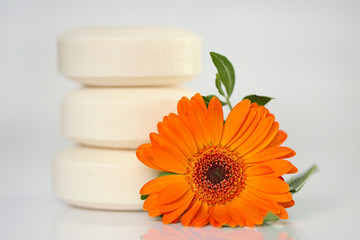Flower Soap.  round soap with flower extract and orange gerbera flower on a light background. Organic Natural Cosmetics